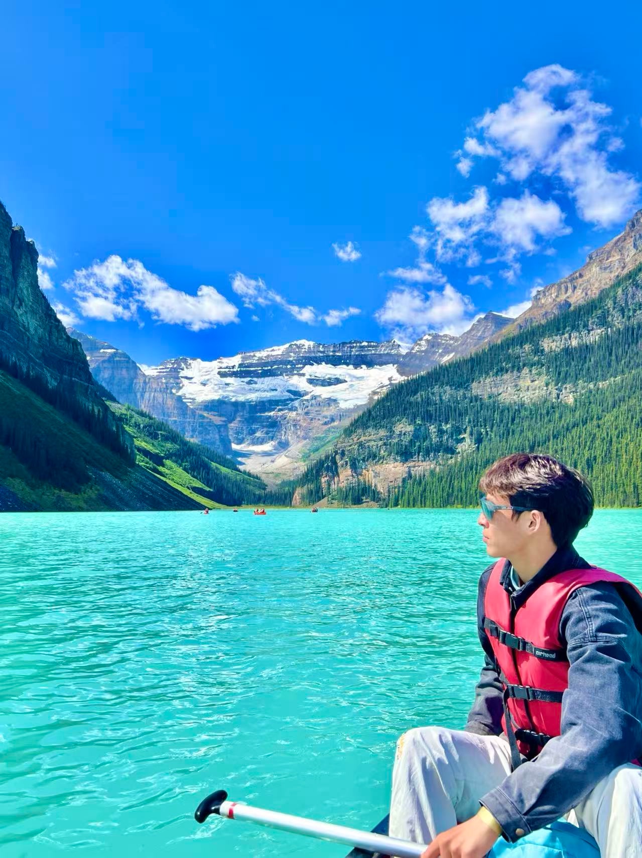 Canoeing on the turquoise waters of Lake Louise with mountains in the background