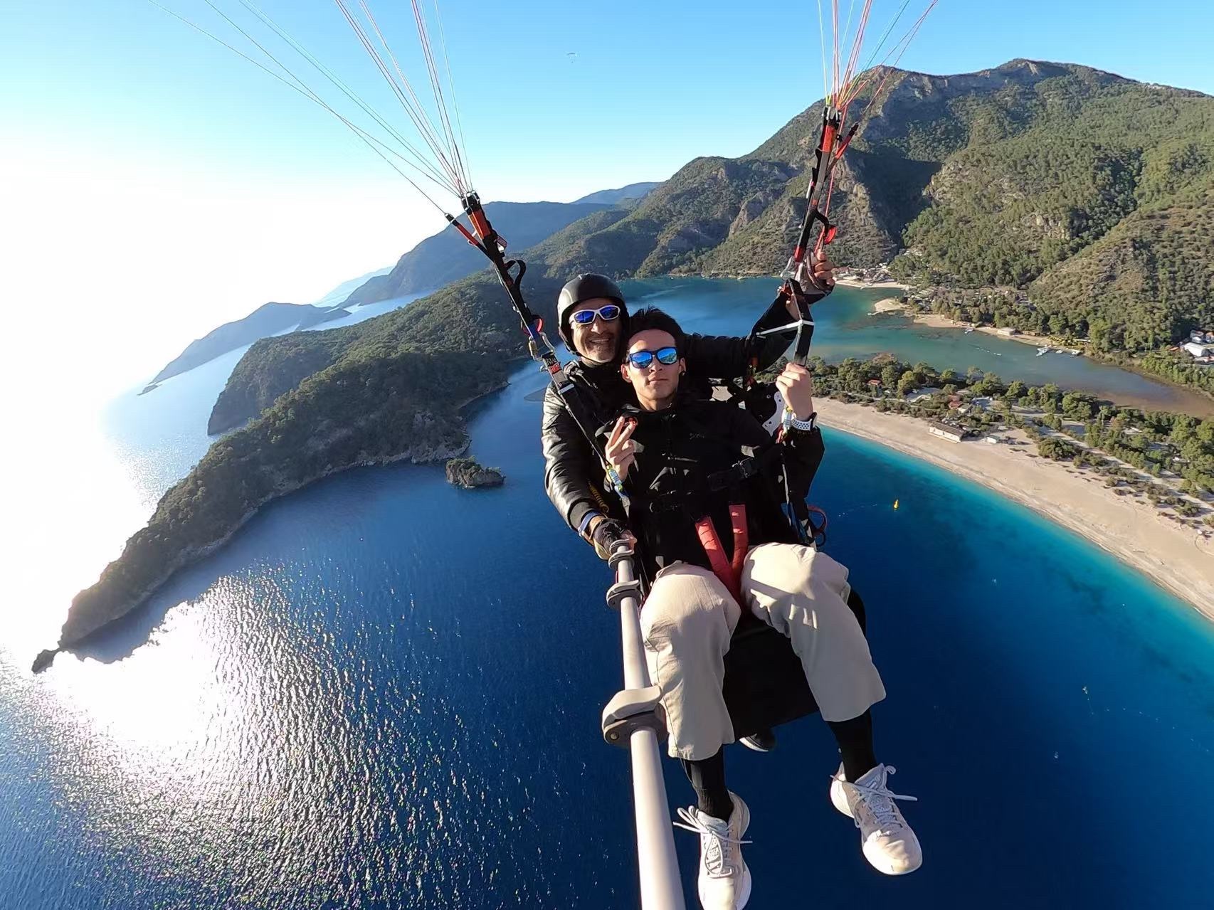 Tandem paragliding above a coastal bay